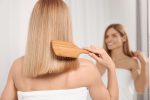 Woman brushing bleached blonde hair