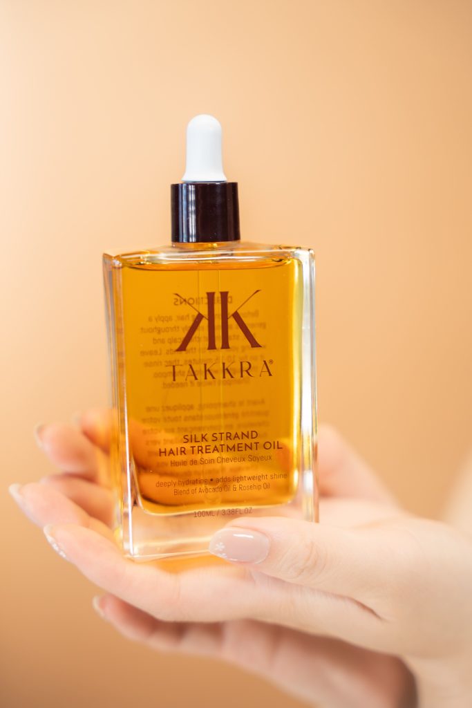 Hands holding the Takkra Hair Oil