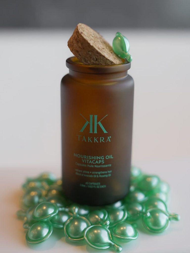 Takkra Nourishing Oil VitaCaps, open bottle with capsules around it