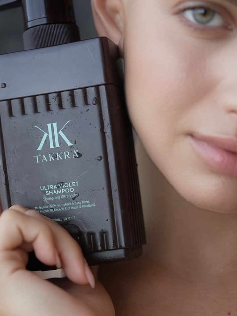Woman holding the Takkra Ultra Violet Shampoo
